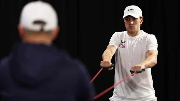 Jack Draper warming up while wearing a hat on court at the Davis Cup