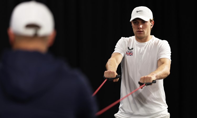 Jack Draper warming up while wearing a hat on court at the Davis Cup