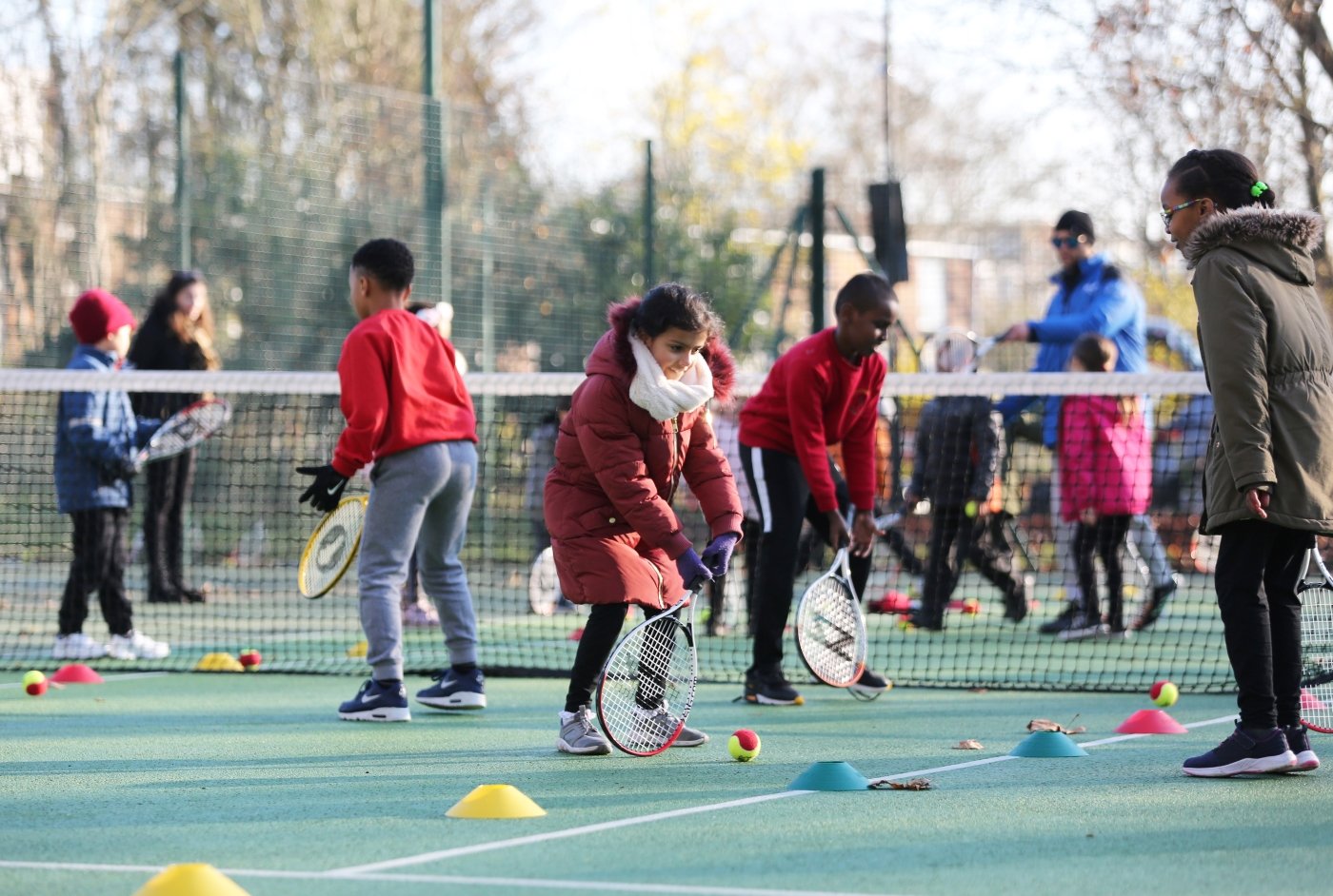 Children playing tennis outside 