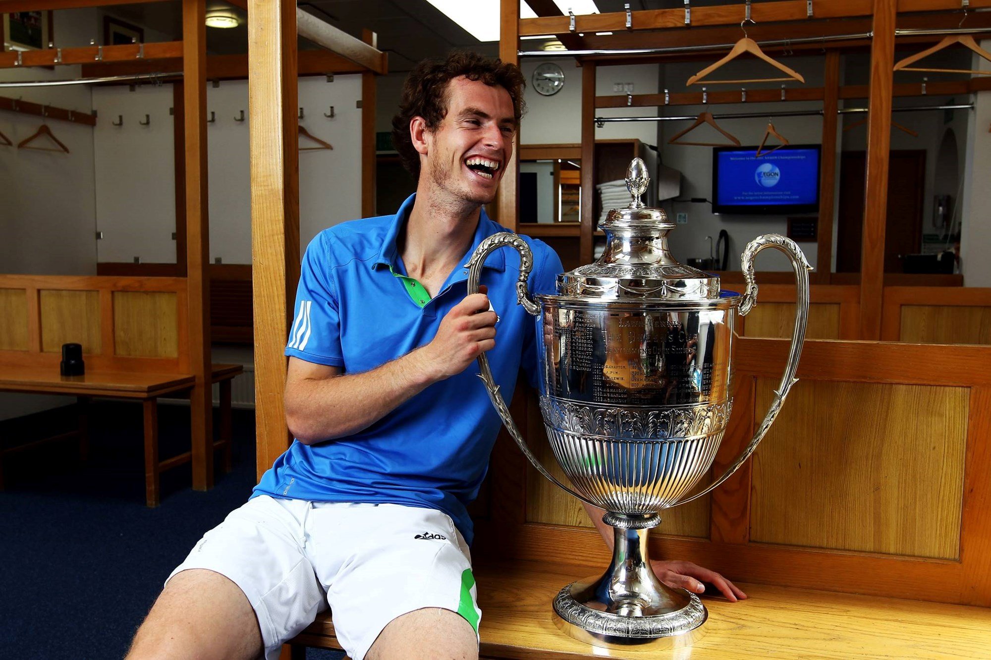 Andy Murray celebrates with his trophy in the dressing room after beating France's Jo-Wilfried Tsonga to win the Queen's Club Championship in 2011