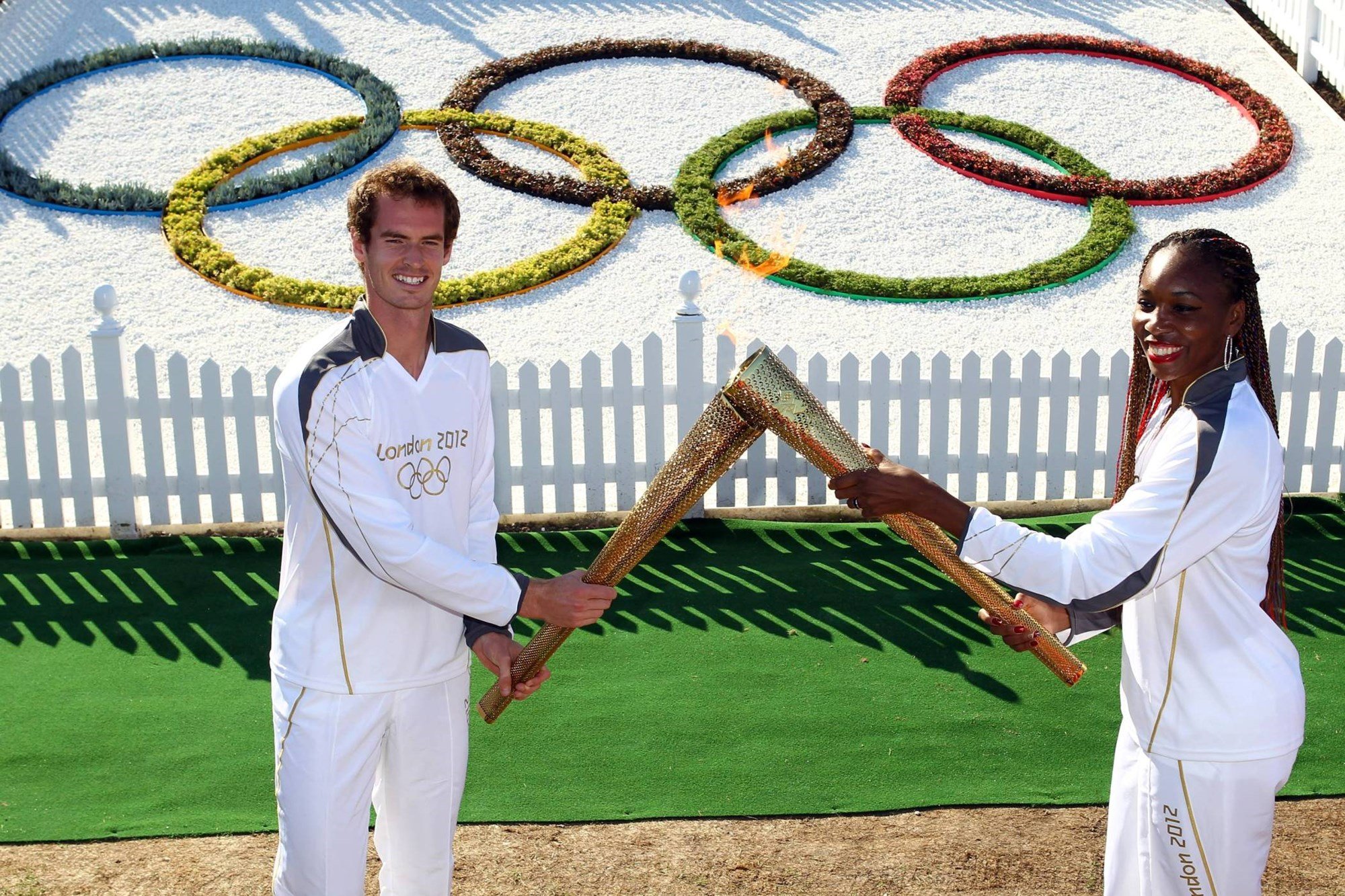 Andy Murray hands the Olympic torch to Venus Williams ahead of the 2012 London Olympics opening ceremony