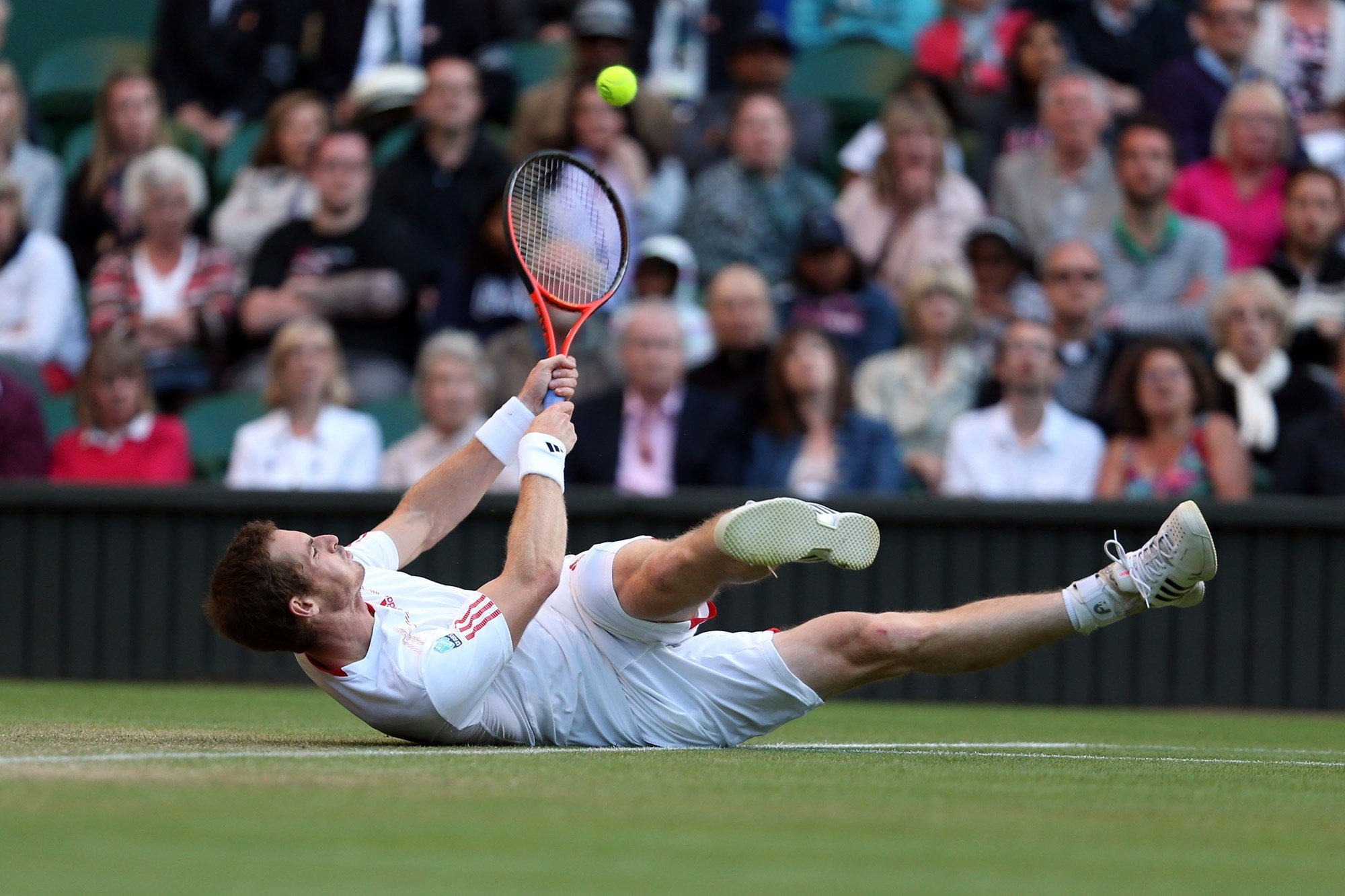 Andy Murray falls as he reaches for a shot during his men's singles third round match against Marcos Baghdatis at Wimbledon 2012