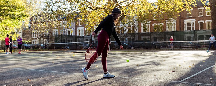 Woman playing tennis in a park