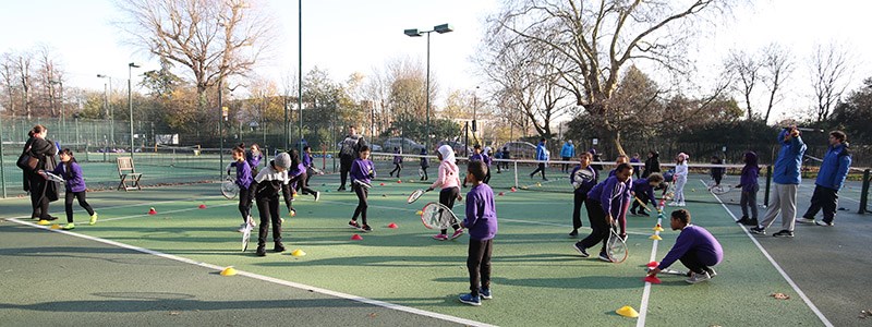 kids taking part in a community tennis session on park tennis courts