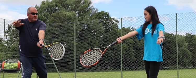 Jonty Solomons coaching a young girl at a local tennis court