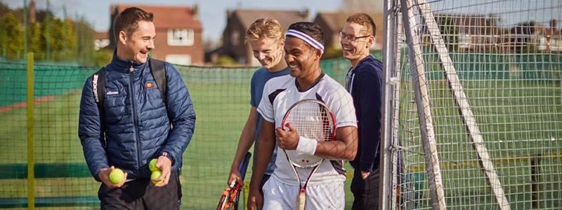 Oli Jones laughing with friends as he enters the court