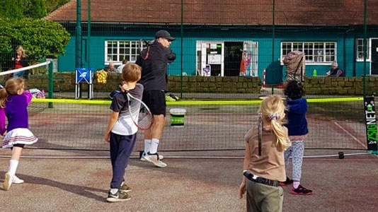 A coach and children as part of the Leeds community tennis programme