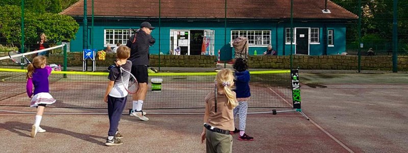 A coach and children as part of the Leeds community tennis programme