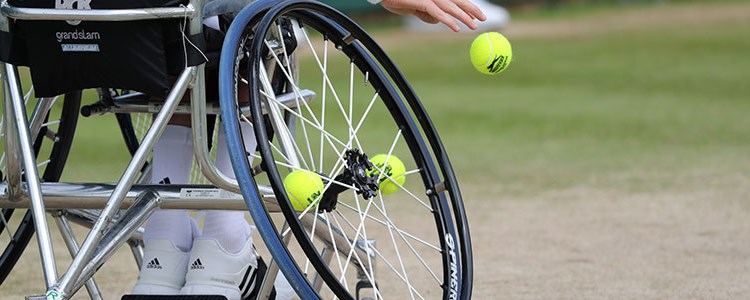 Wheelchair and tennis balls on grass