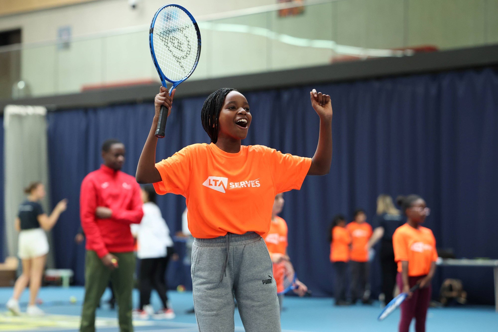 Young child celebrating on court at an LTA SERVES event