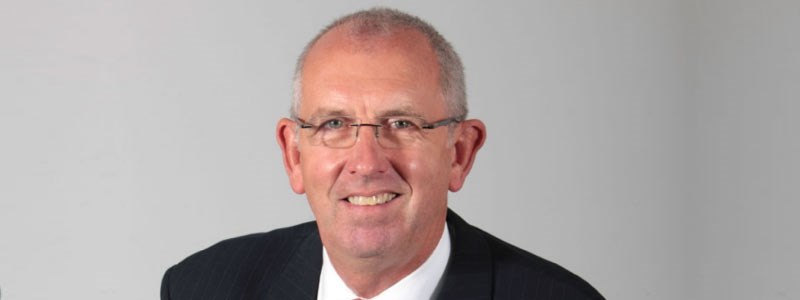 headshot image of chairman graham watson in a suit smiling