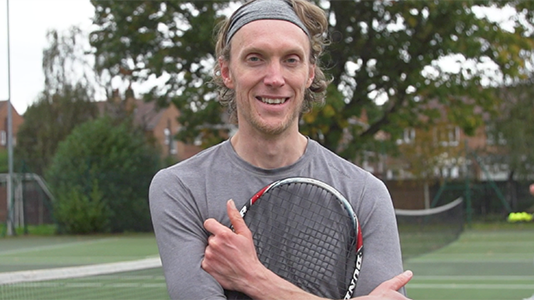 Andy Wright holding a racket close up