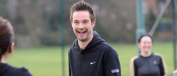 Oli Jones, a tennis coach, smiling