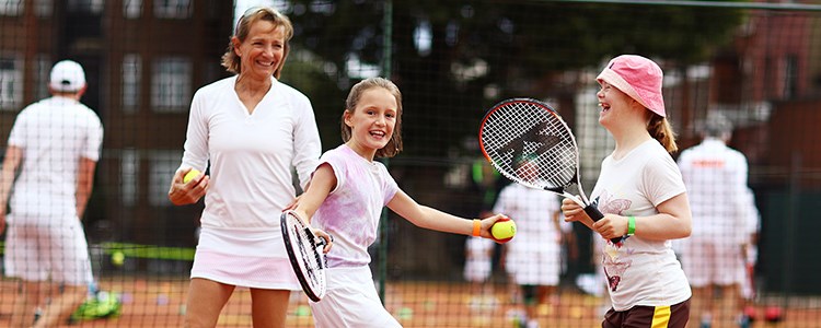Young girls smiling and laughing playing tennis