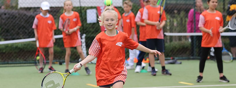 A girl runs to hit a ball as part of the LTA Youth Start programme