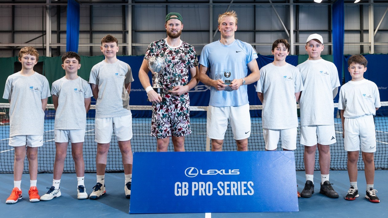 Danish tennis player Christian Sigsgaard and Anton Matusevich holding their Lexus GB Pro Series Glasgow winners and runner-up trophies on court with the ball boys stood next to them