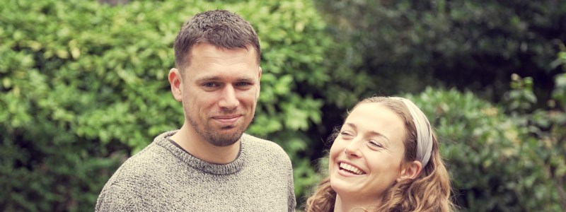 close up image of steve and elle standing together with steve smiling and elle laughing