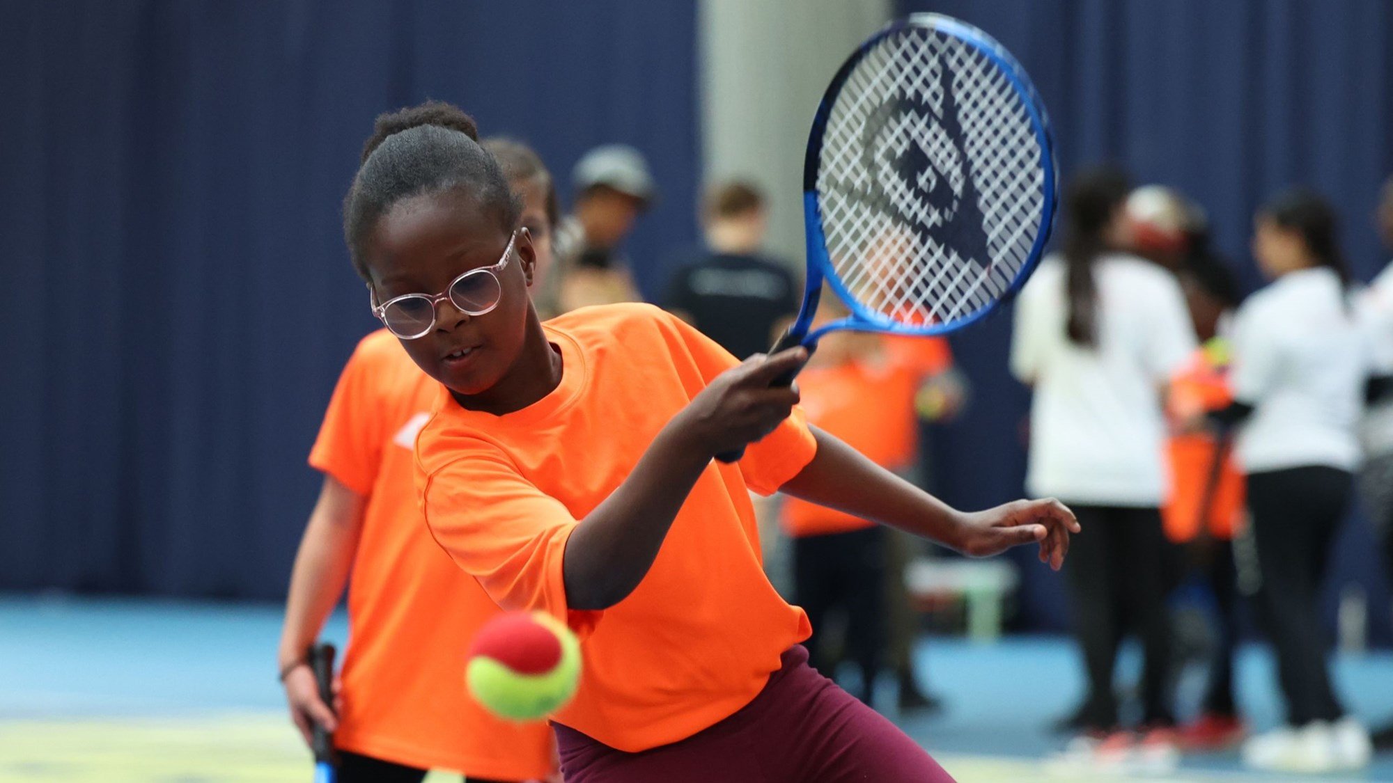 A young girl hitting a forehand on court at an LTA SERVES session