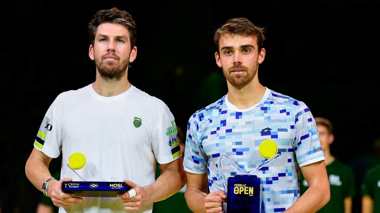 Cam Norrie holding the Moselle Open runner-up trophy next to champion Benjamin Bonzi