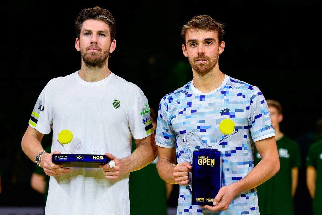 Cam Norrie holding the Moselle Open runner-up trophy next to champion Benjamin Bonzi