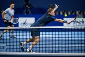 Luke Johnson stretches for a backhand volley during doubles action in Antwerp