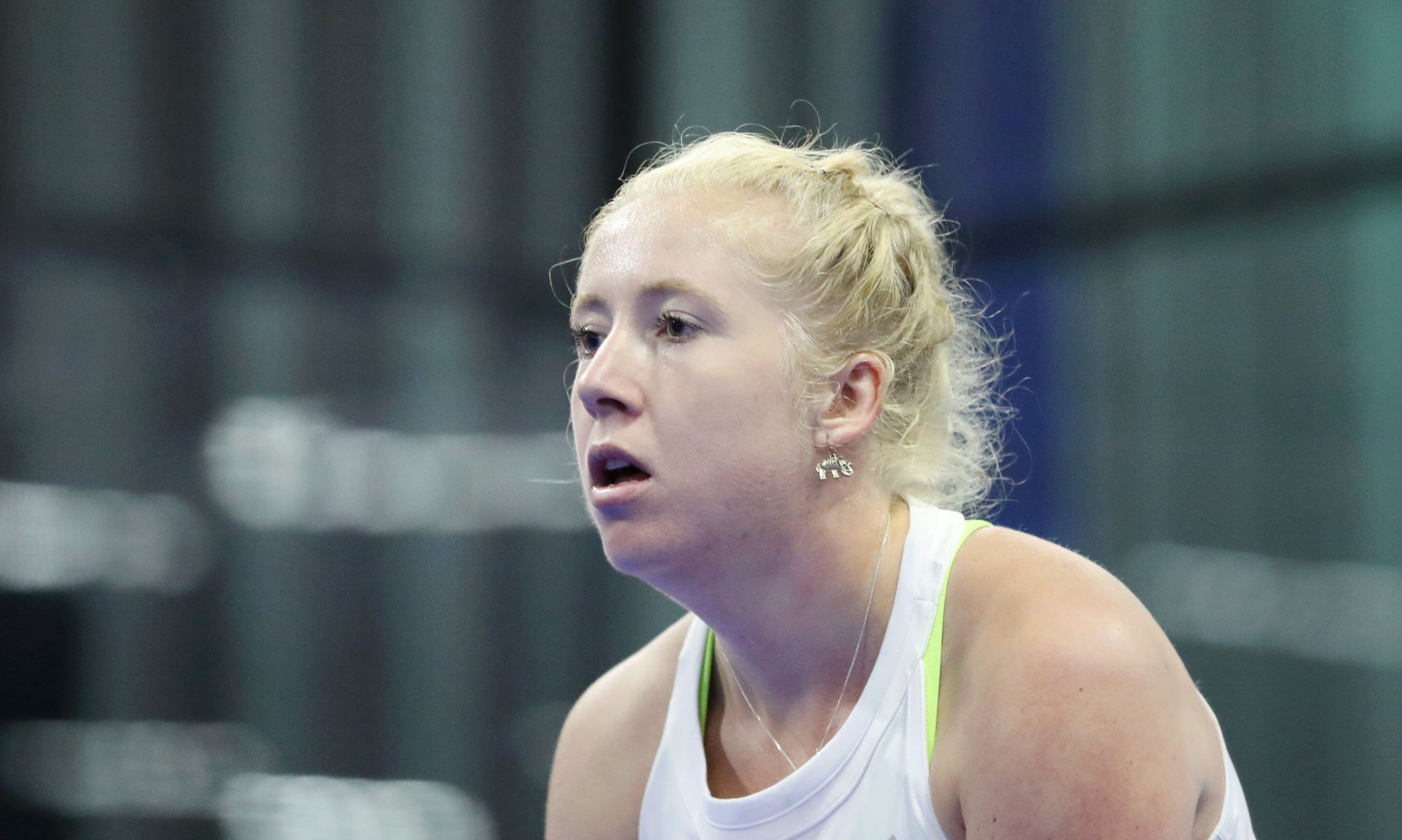 A close up picture of British Padel player Lisa Phillips  wearing a white top with a flag of Great Britain