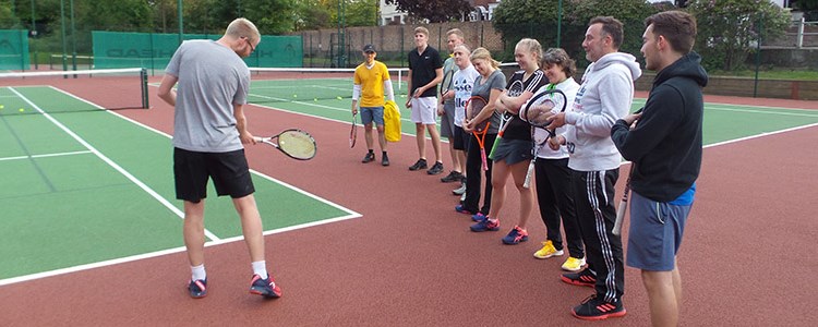 luke house on court coaching players  on  how to swing the racket