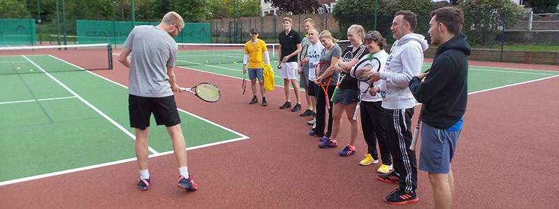 luke house on court coaching players  on  how to swing the racket