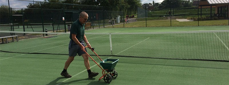 ken thomas pushing line marking machines on outdoor grass court