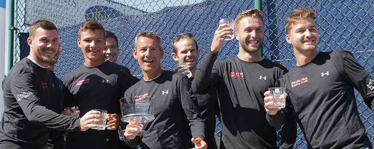 mens players wearing full sleeve black tops with trophies in hand