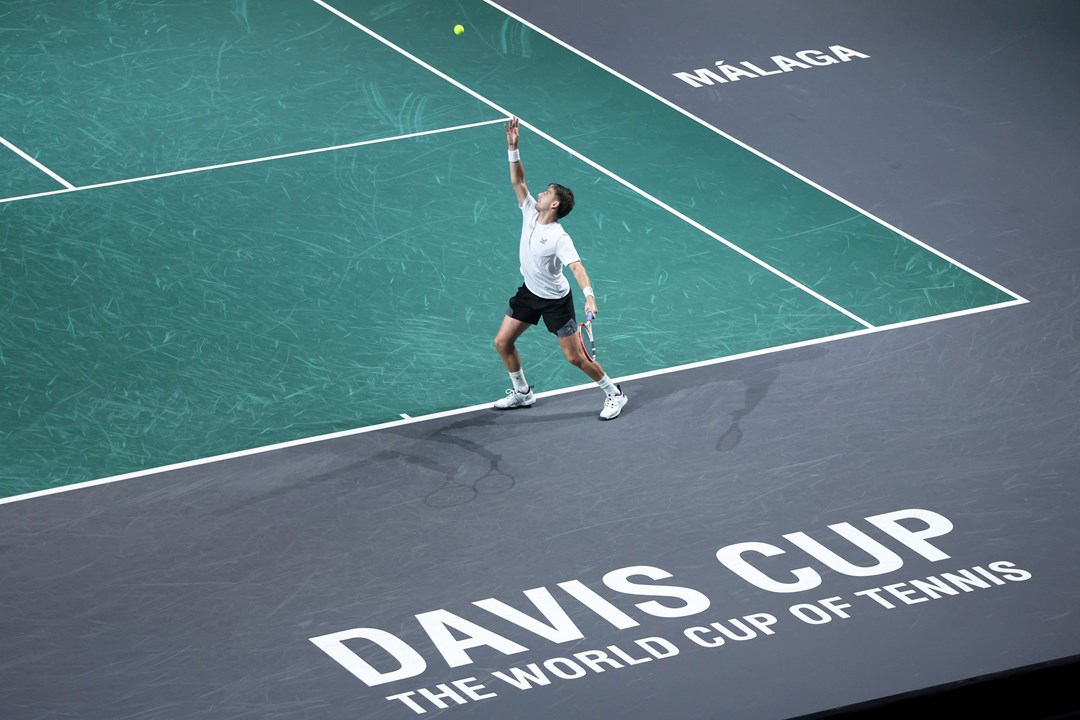 Cam Norrie serving on court, with 'Davis Cup, the world cup of tennis' written on the court