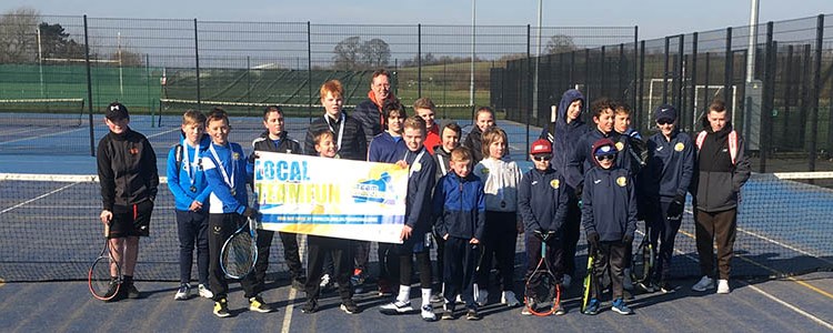 group of youth and coach standing on court at Cheslyn Hay tennis club holding a Team Challenge sign