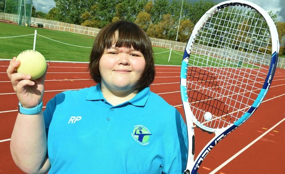 rosie pybus holding a tennis ball and racket on court