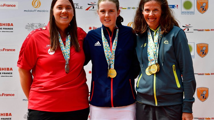 Anna Mcbride wearing her medal posing with two other players