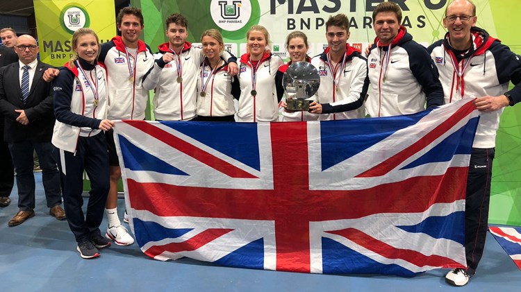 Great Britain University Tennis Team posing holding a large union jack flag