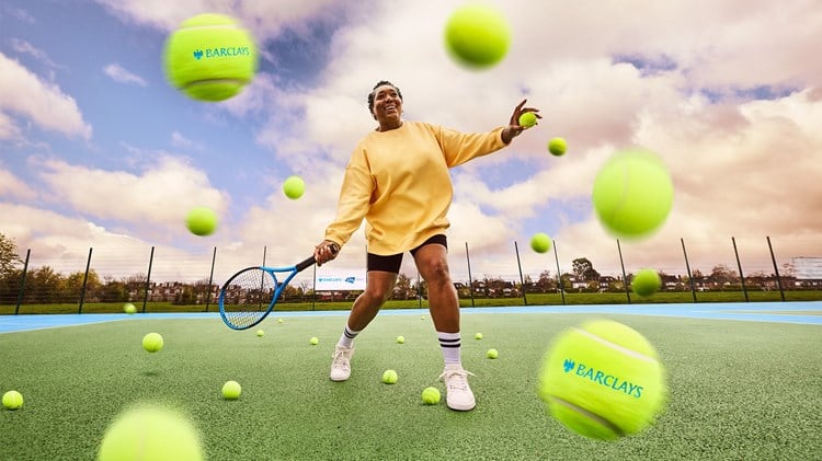 A female tennis player surrounded by tennis balls while two tennis balls with the 'Barclays' logo also featuring