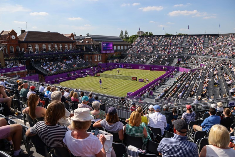 A view of lawn court tennis match from a corner stand