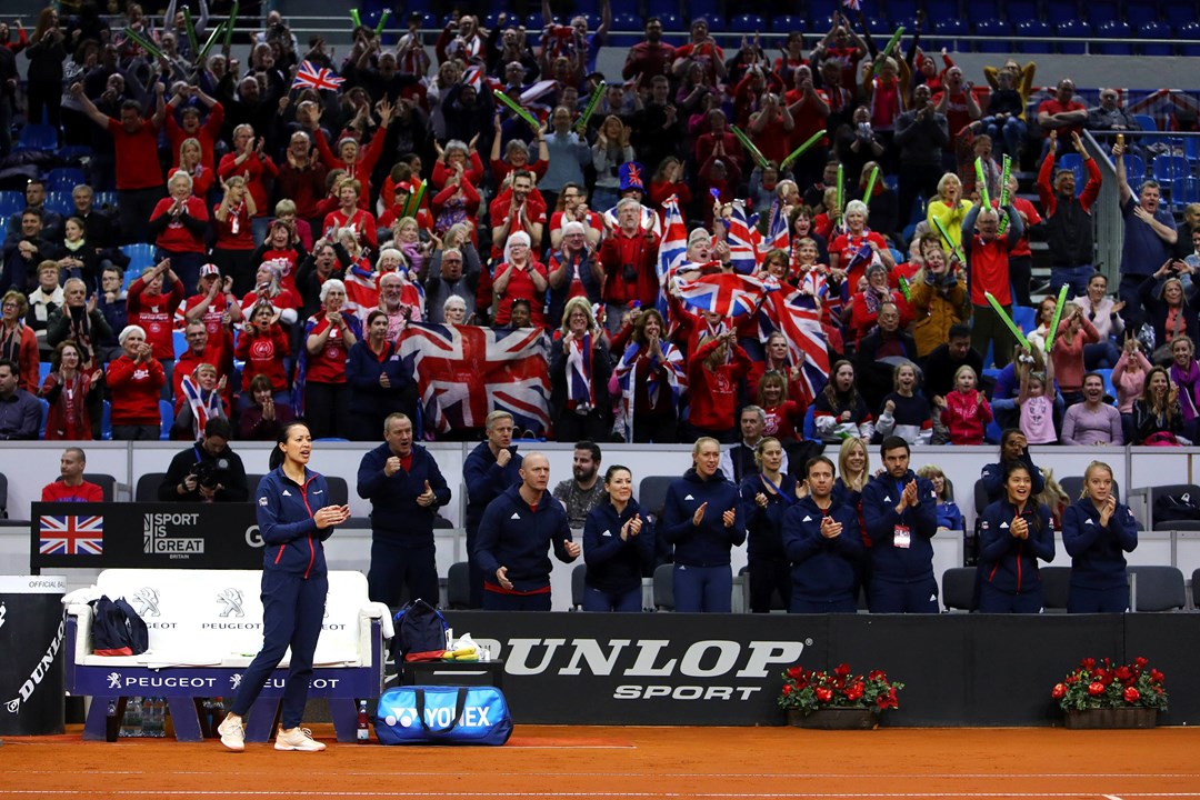 Tennis player clapping with fans in background