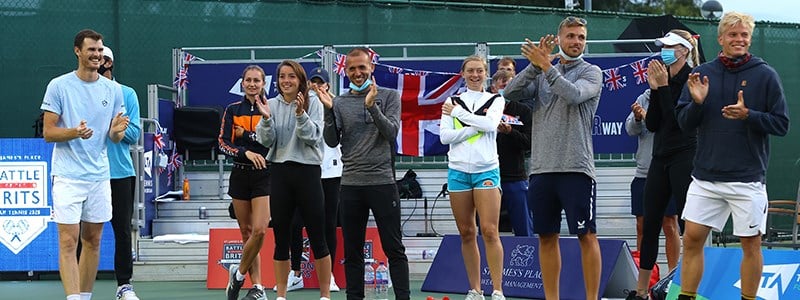 Tennis players clapping at the end of a tennis match.