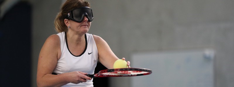 virtually impaired woman holding ball on racket