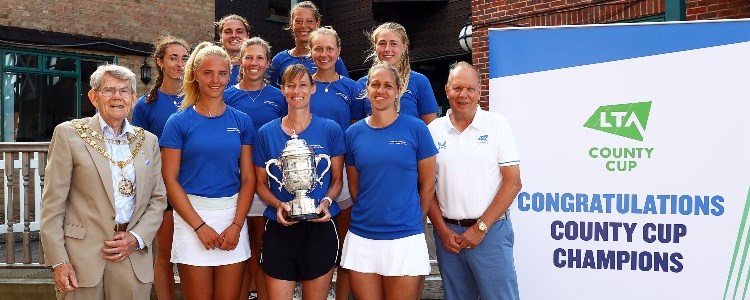 The Herefordshire ladies team standing in a group smiling and holding the County Cup Trophy