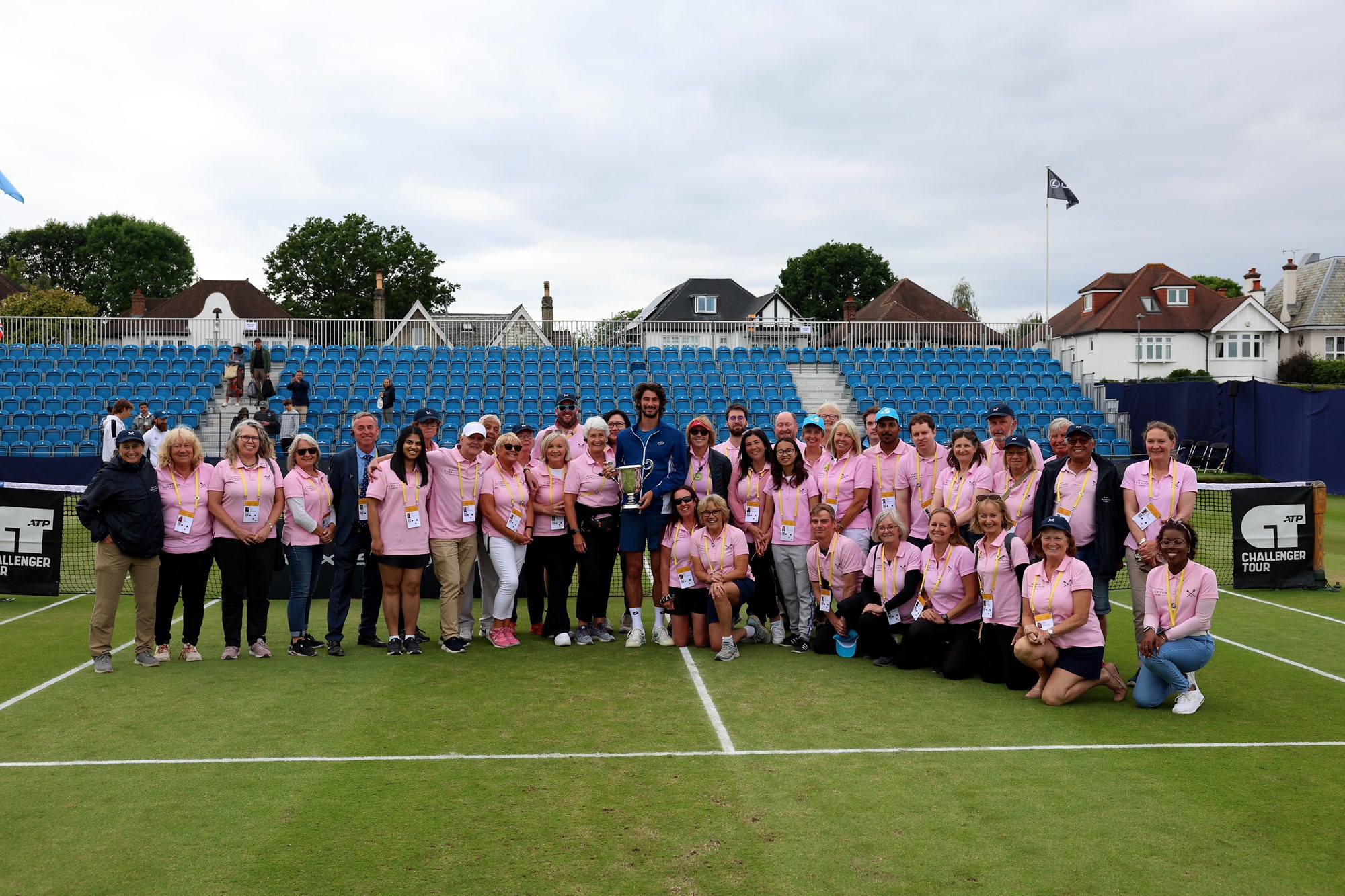 The Surbiton volunteers posing on court with 2024 champion, Lloyd Harris