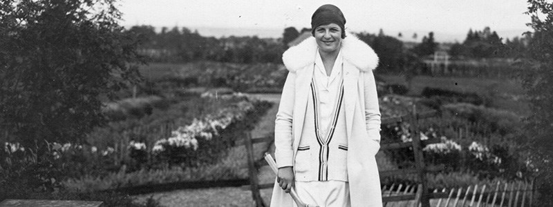 Betty Nuthall smiling and holding a tennis racket