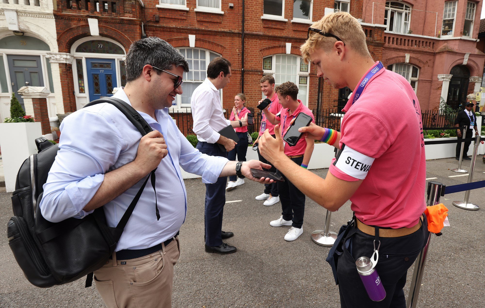 A Steward scanning a fan's ticket outside the Queen's Club