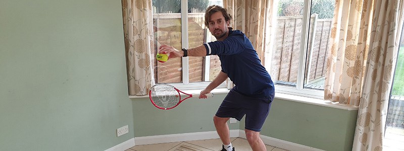 Matt Smith posing with tennis racket at home